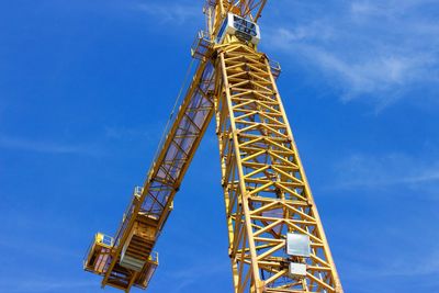 Low angle view of crane against blue sky