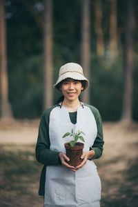 Portrait of smiling man standing against plants