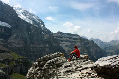 Man on rock against sky