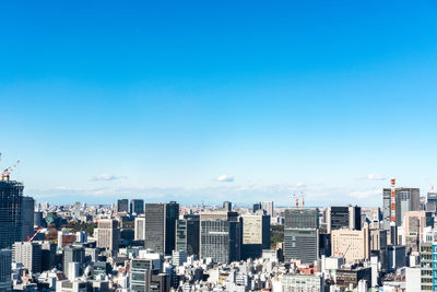 Modern buildings in city against blue sky