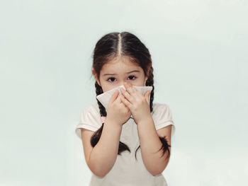 Portrait of a girl drinking against white background