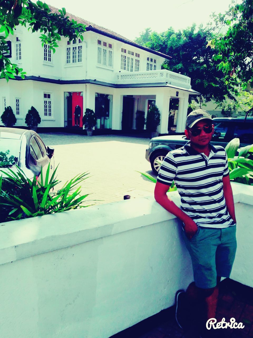 MAN IN FRONT OF BUILT STRUCTURE AGAINST TREES