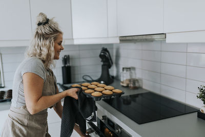 Woman in kitchen preparing cupcakes