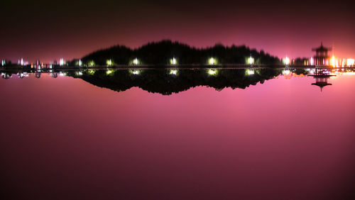 Scenic view of lake against sky at night