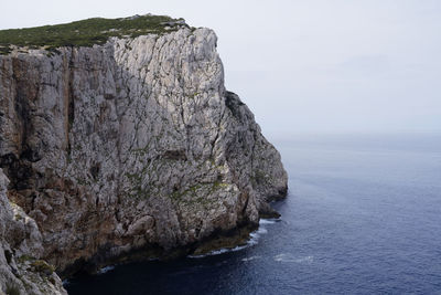 Rock formations by sea against sky