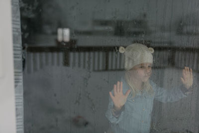 Portrait of woman standing by window