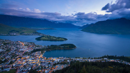 Aerial view of city by sea against sky