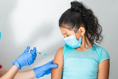 Children's nurse injecting brown girl's arm. home-to-home vaccination plan