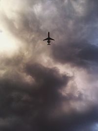 Low angle view of silhouette airplane flying in sky