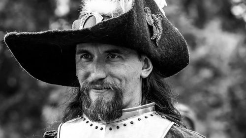 Close-up portrait of man wearing hat against trees