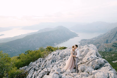 Woman standing on mountain against sky