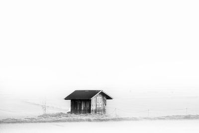 House on field against sky during winter