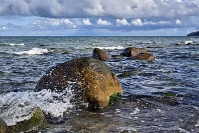 Rocks in sea against sky