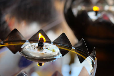 Close-up of lit tea light candles in temple