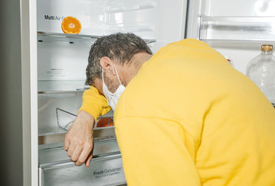 Rear view of man having food at home