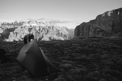 Rear view of woman looking at mountains against sky