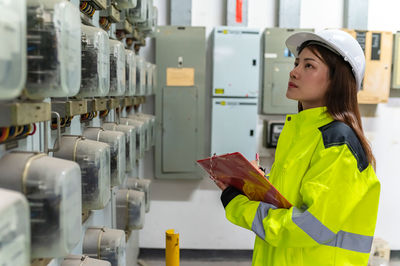 Portrait of young woman standing in factory