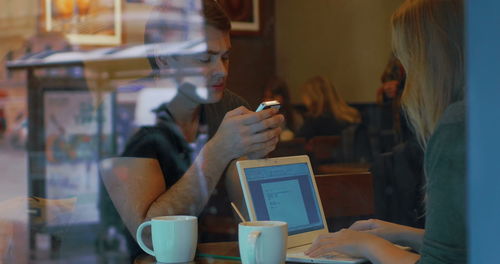 Midsection of woman using mobile phone in restaurant