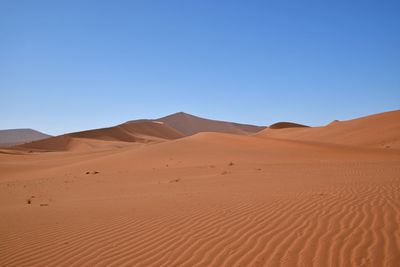 Scenic view of desert against clear blue sky