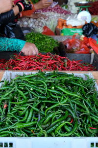 Low section of woman with vegetables for sale in market