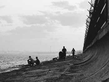 People on beach against sky
