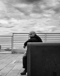 Side view of woman sitting on bench