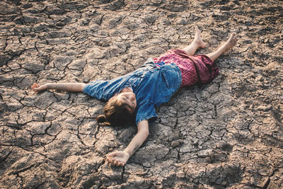 High angle view of child lying on sand