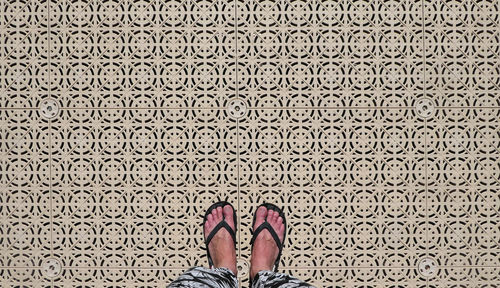Low section of woman standing on patterned floor
