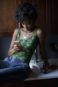 Young woman using mobile phone at home