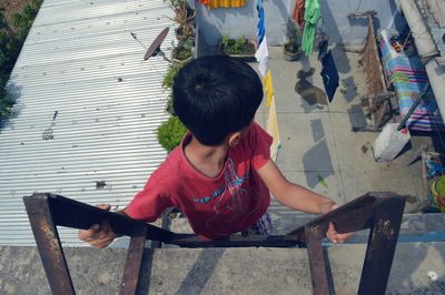 High angle view of girl sitting on bench