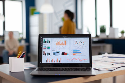 Information of charts and diagrams on laptop at table