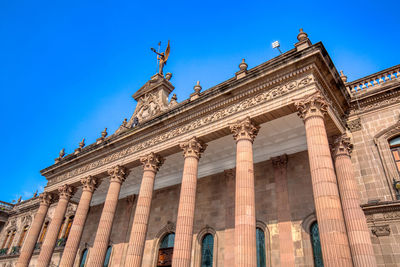 Low angle view of historical building against blue sky