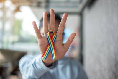 Person with multi colored ribbon at table