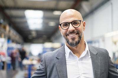 Portrait of smiling businessman in factory