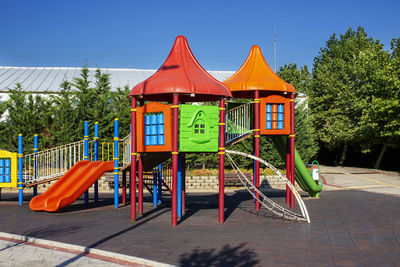 View of empty playground against clear blue sky