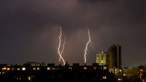 Low angle view of illuminated buildings against sky at night