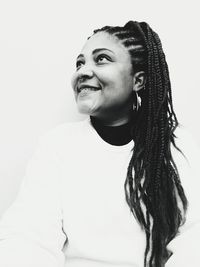 Portrait of smiling young woman against white background