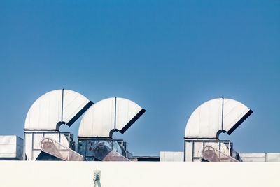 Low angle view of buildings against clear blue sky