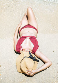 High angle view of woman relaxing on sand at beach