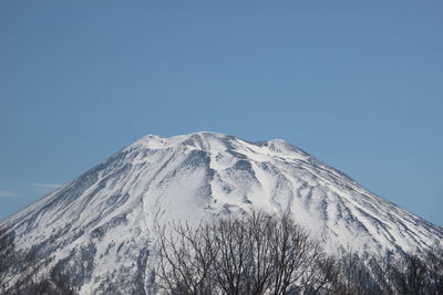 Scenic view of snowcapped mountains against clear blue sky