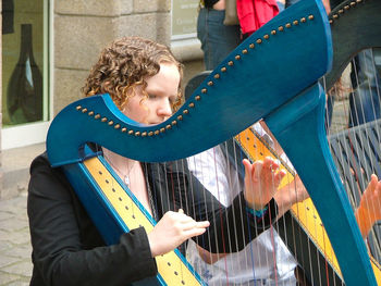 Musician playing harp on street