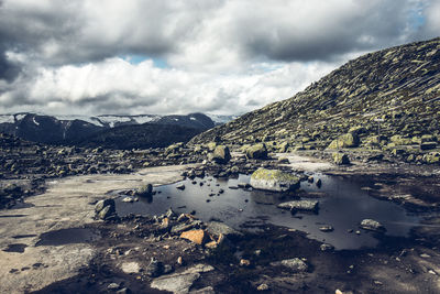 Scenic view of lake by mountain against sky