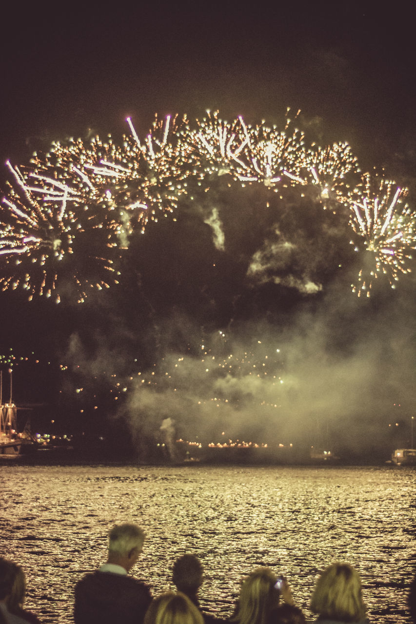 FIREWORK DISPLAY OVER SEA AGAINST SKY