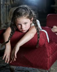 Portrait of girl sitting on red floor