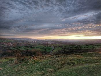 Scenic view of field against cloudy sky