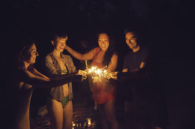 Friends playing with sparklers at night