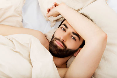 Portrait of young man lying on bed