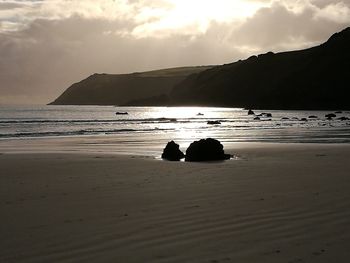 Silhouette of beach against sky during sunset