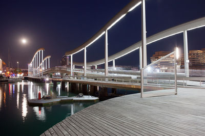 Illuminated bridge over river at night