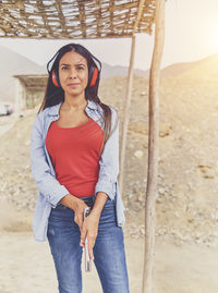 Portrait of young woman standing at beach